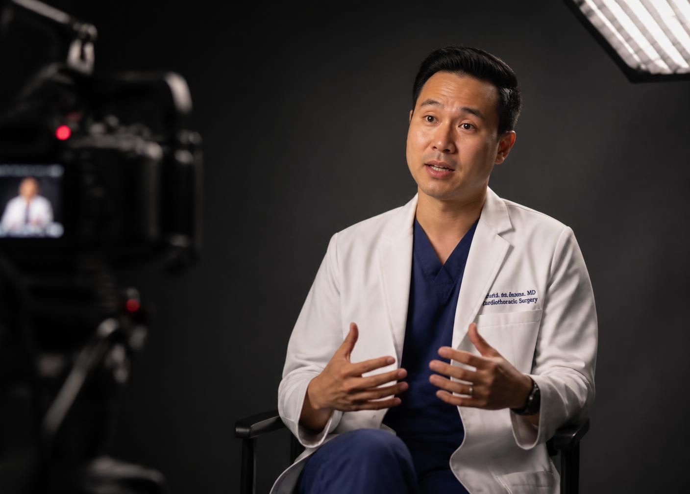 Physician being interviewed on camera in a minimal studio